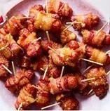 ( I. )Pigs in a blanket Carnaciori subtiri inveliti in bacon,prajiti la cuptor.Pret:8,99 RON/ 100 g. Sos 3,99 RON/100 g.